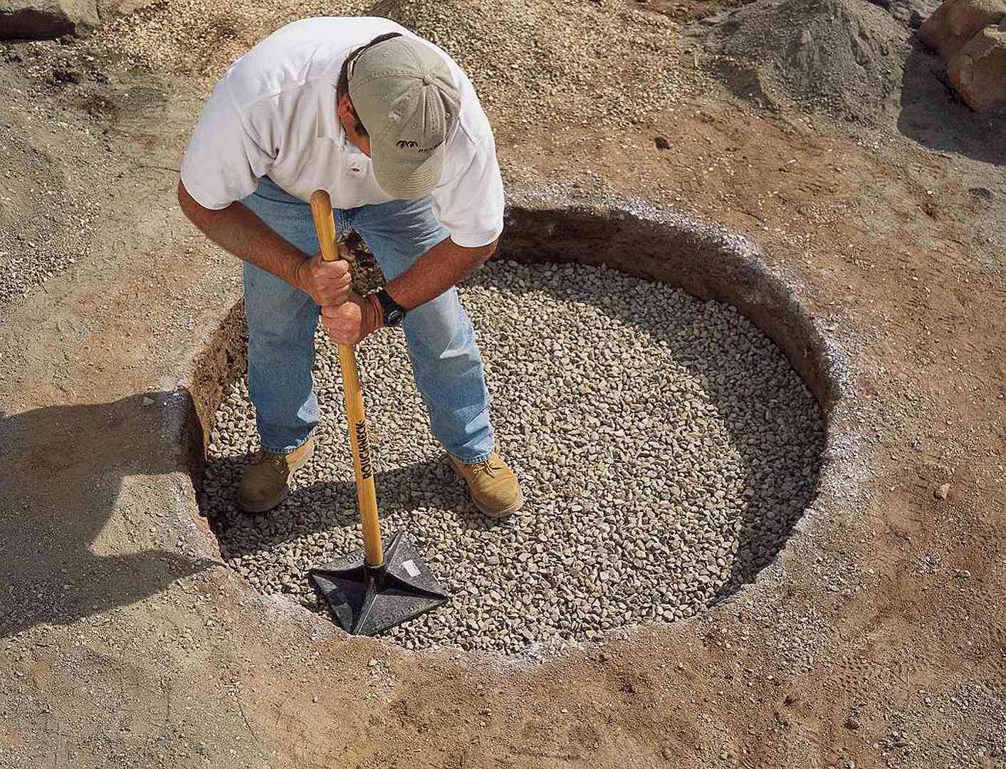 packing gravel into base of fire pit