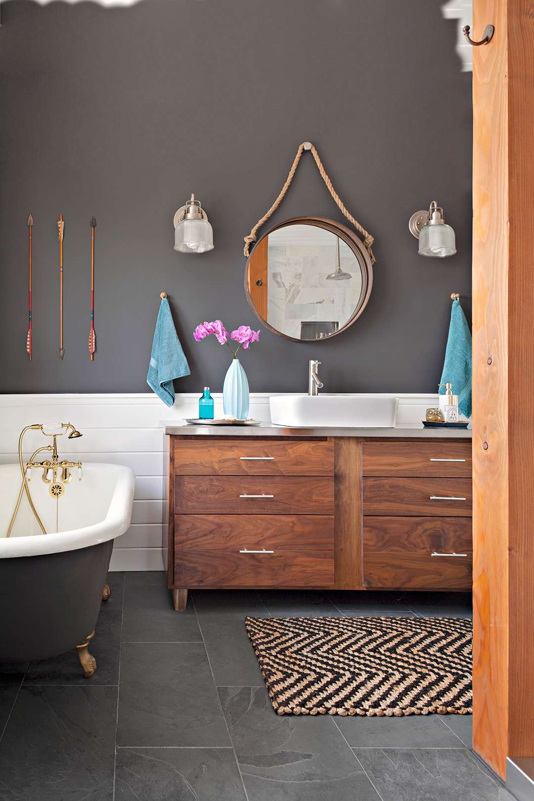 charcoal colored walls and floor tiles with wooden vanity