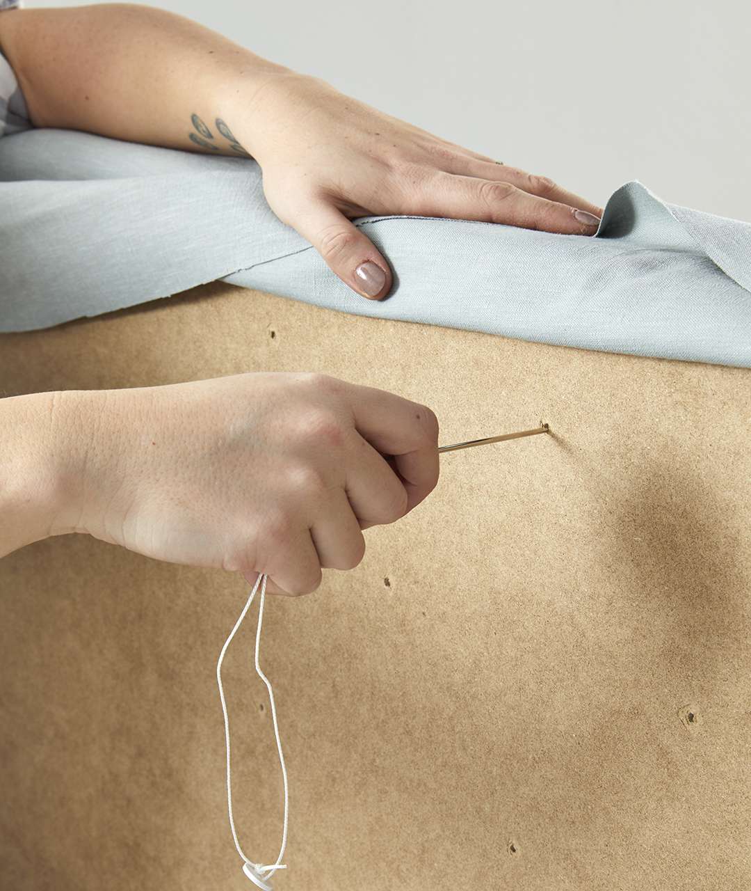 guiding tufting needle into holes for tufted bench