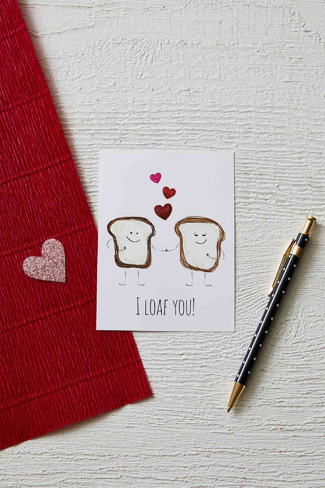 illustrated slices of bread valentine next to a black and gold pen