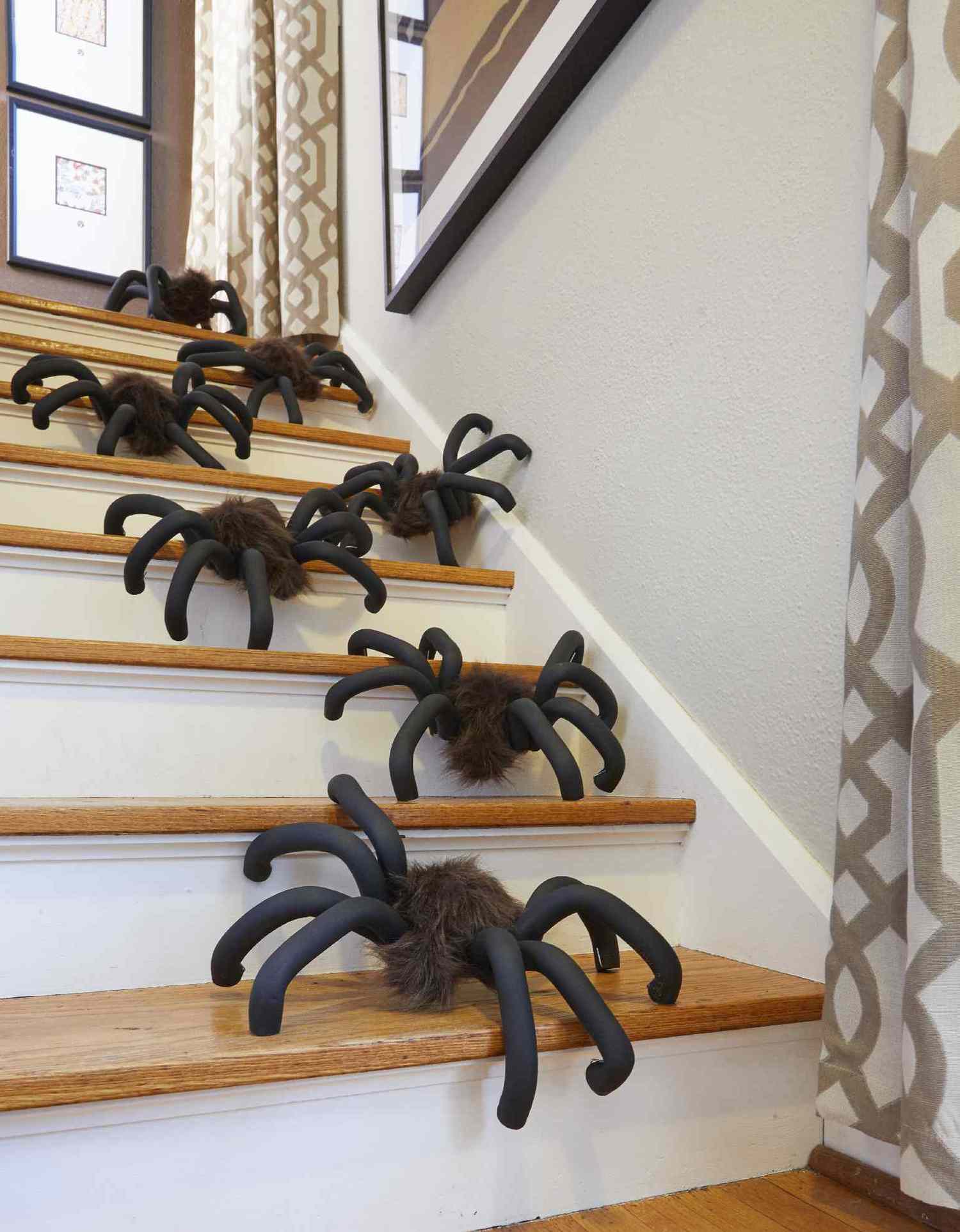 Large DIY fuzzy spiders climbing in a line down stairs