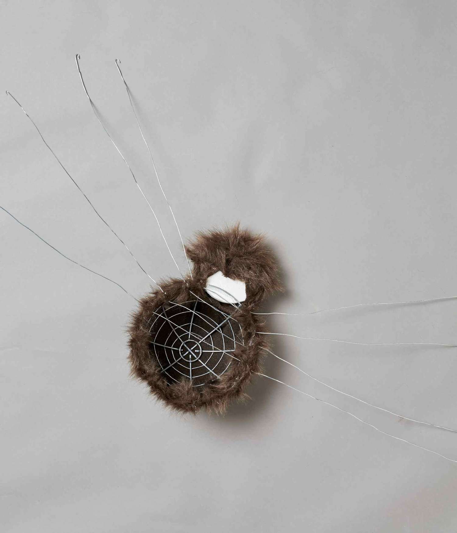 Faux brown fur covering wire frame and foam ball to look like a spider