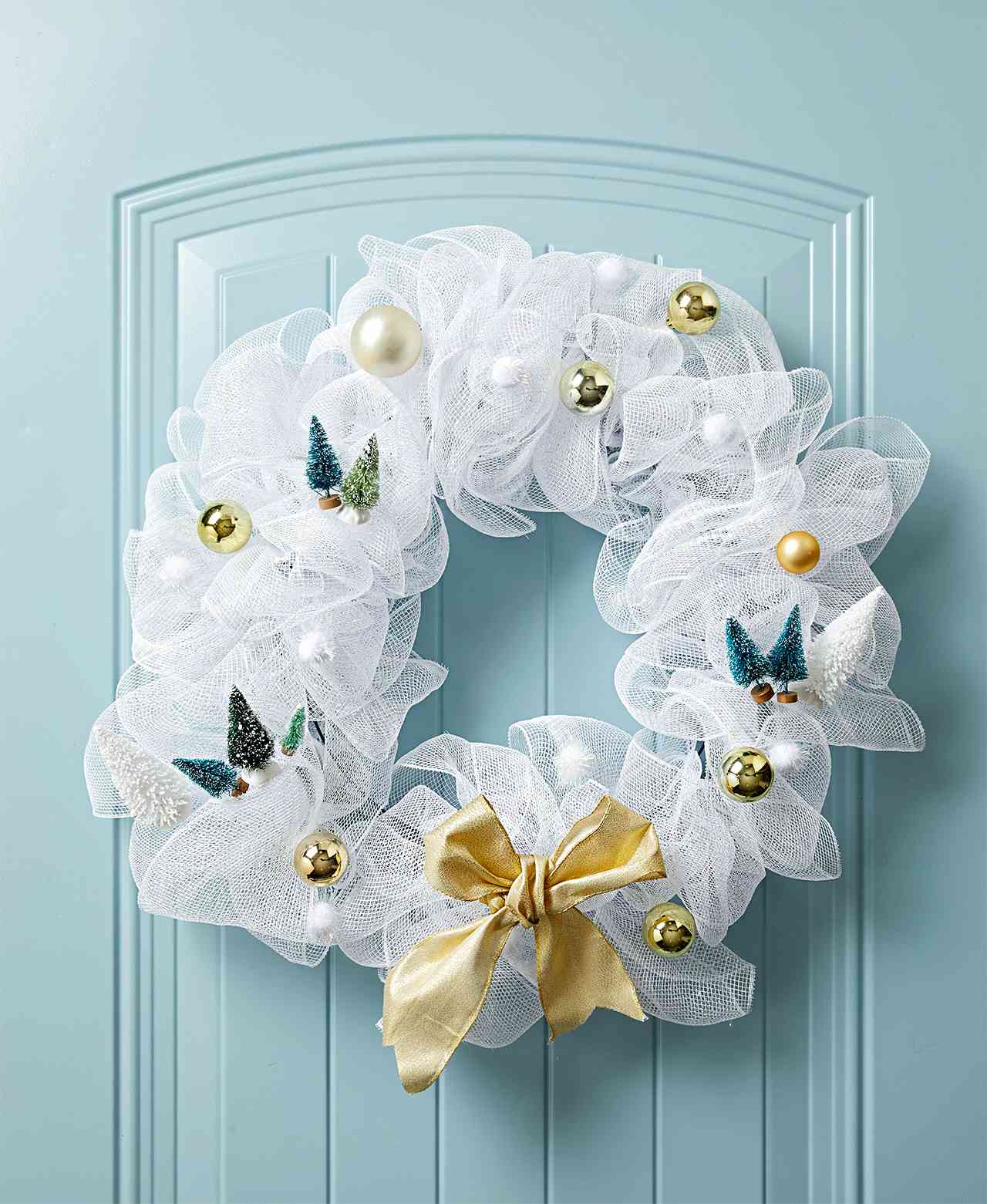 light blue door with gauze wreath and knick-knacks
