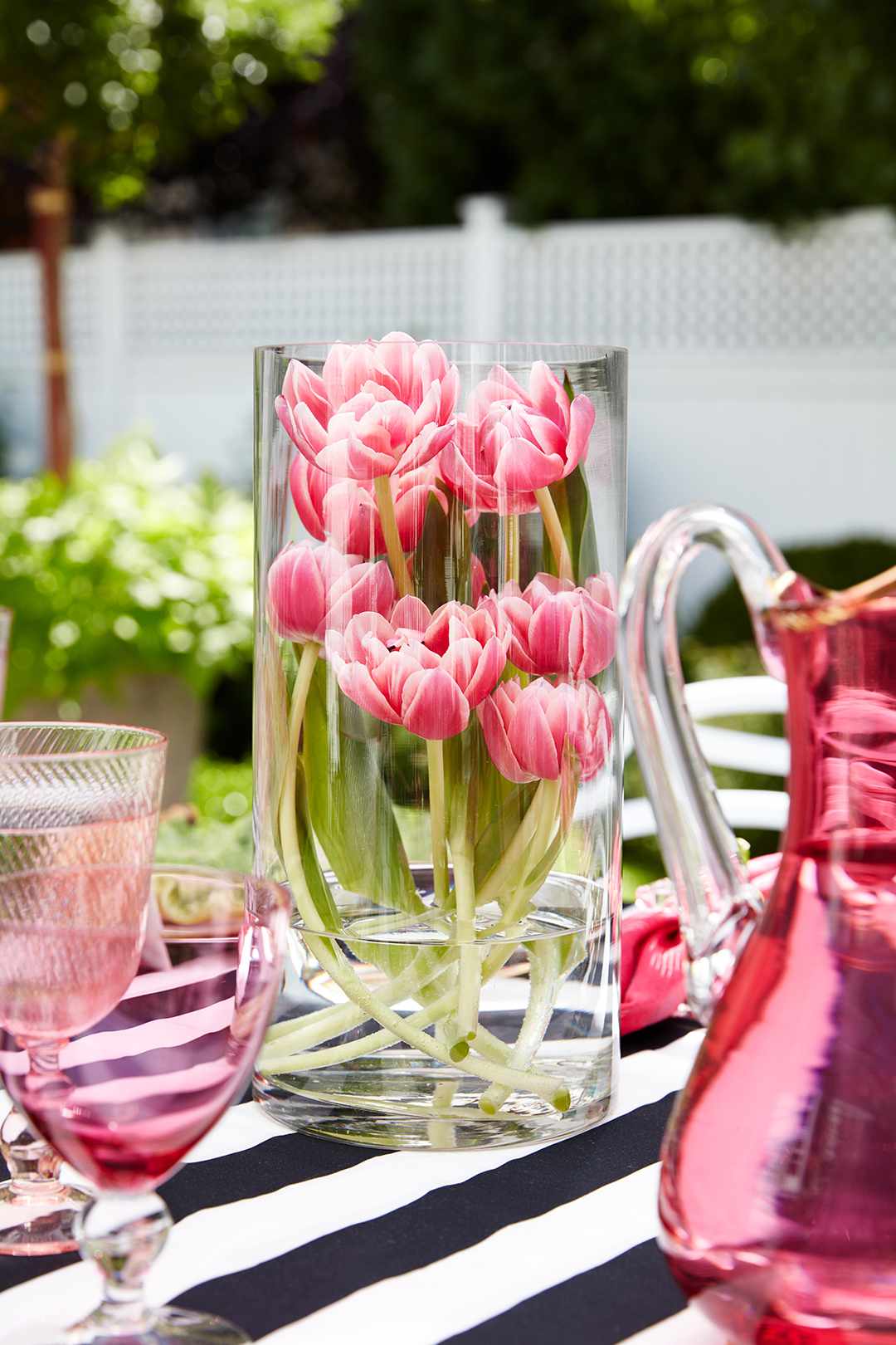 tulips in glass vase on striped table