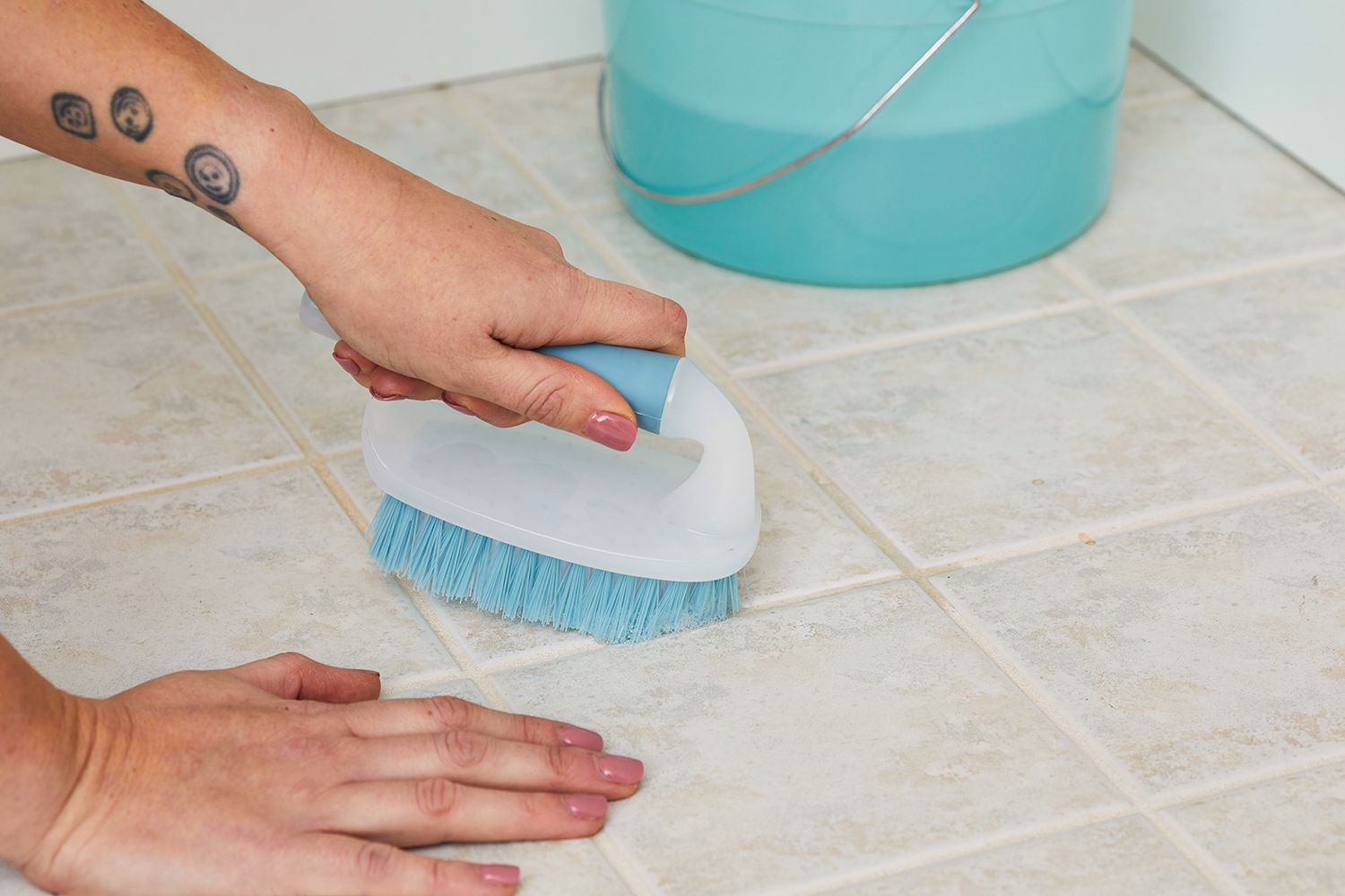 scrubbing tile cracks with blue brush