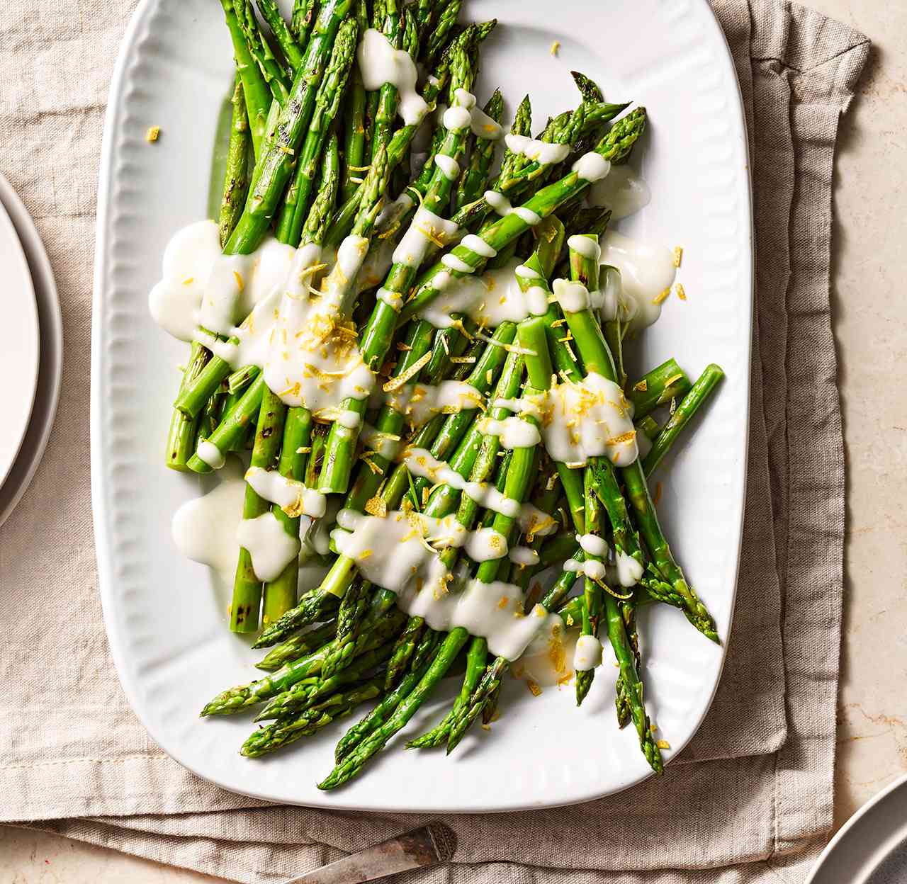 Grilled Asparagus with Toum on white serving plate