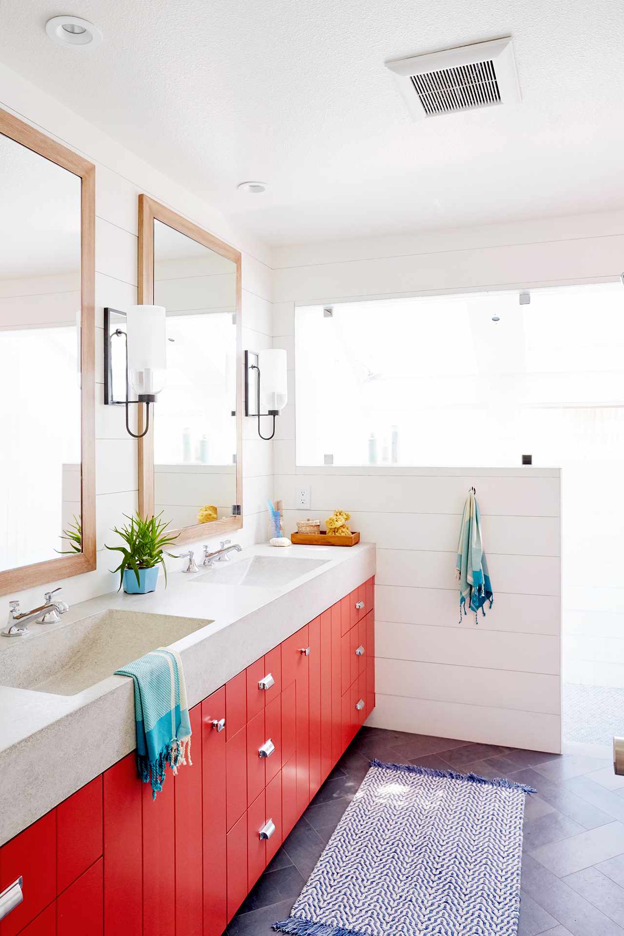 bathroom with orange cabinets and dual mirrors