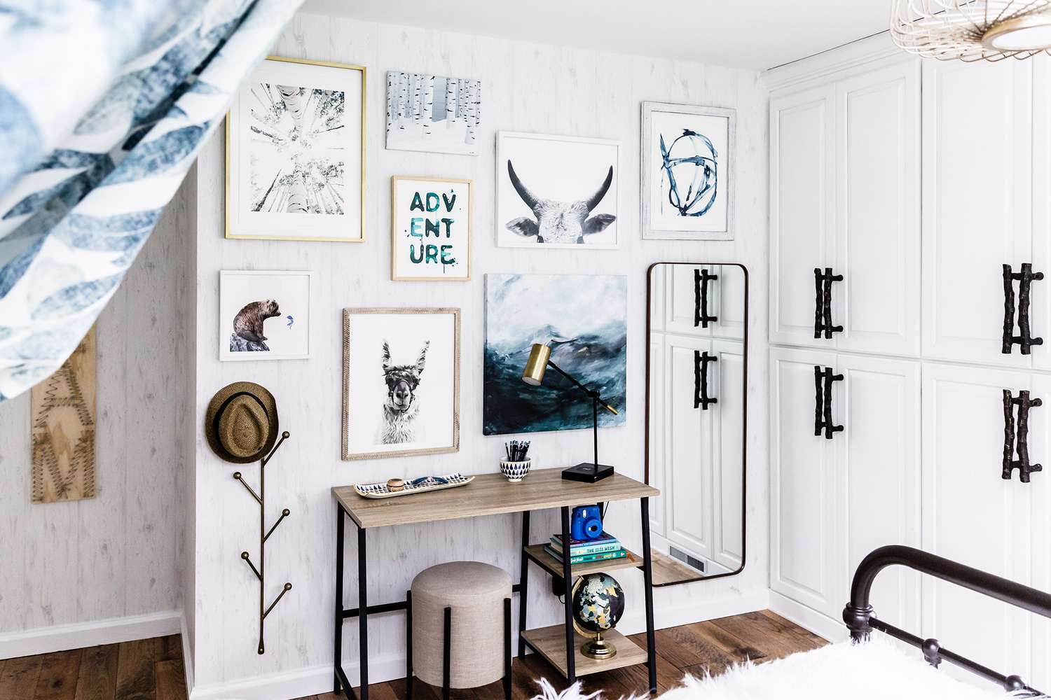 white bedroom with wall art and wood desk