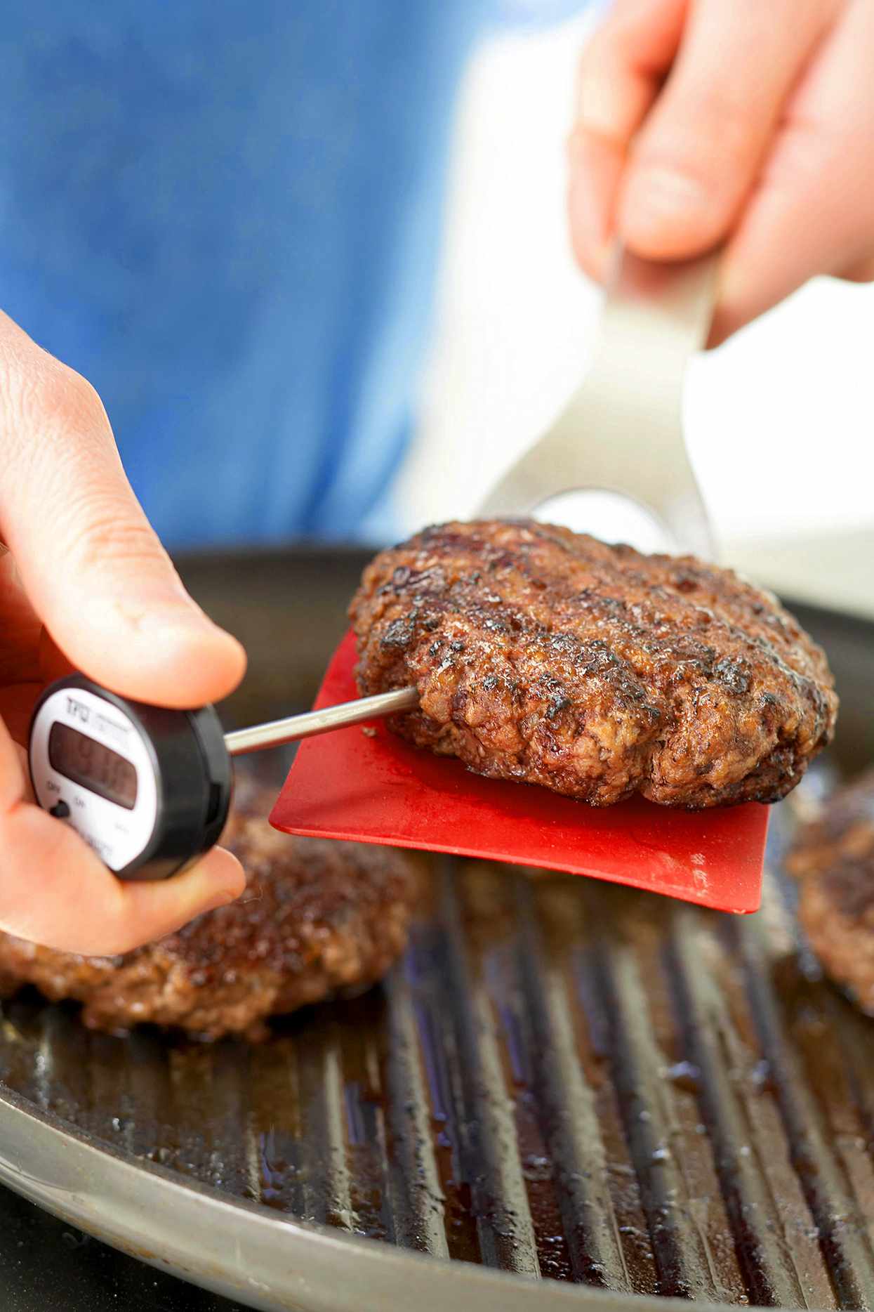 inserting meat thermometer into grilled patty