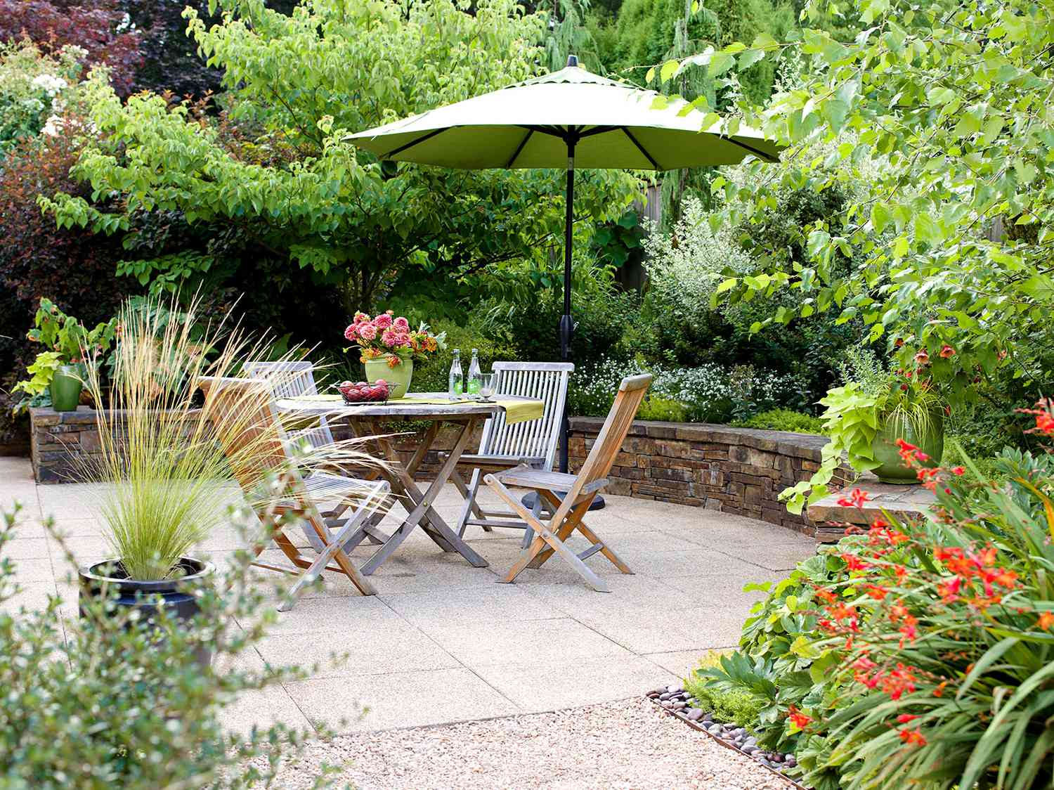 outdoor dining with umbrella and retaining wall