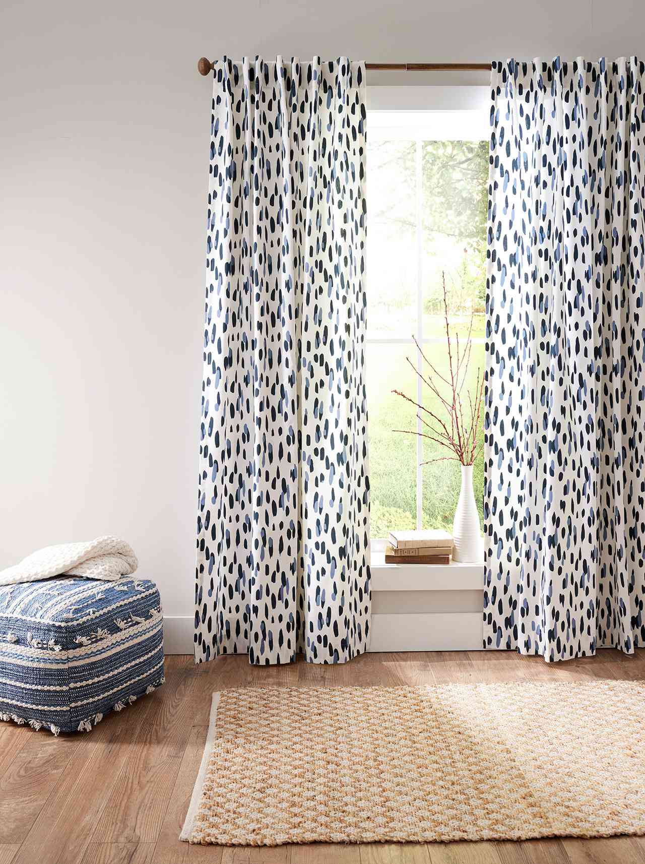 hung blue and white graphic curtains with blue ottoman