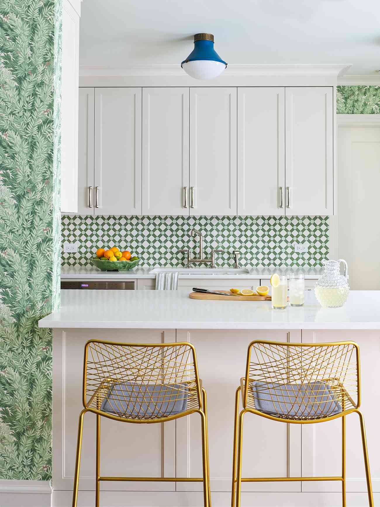 white green kitchen counter space with gold chairs