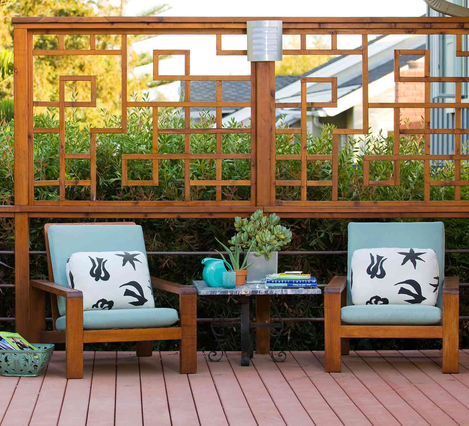 two light-blue cushioned chairs in front of upper railing wood design on deck