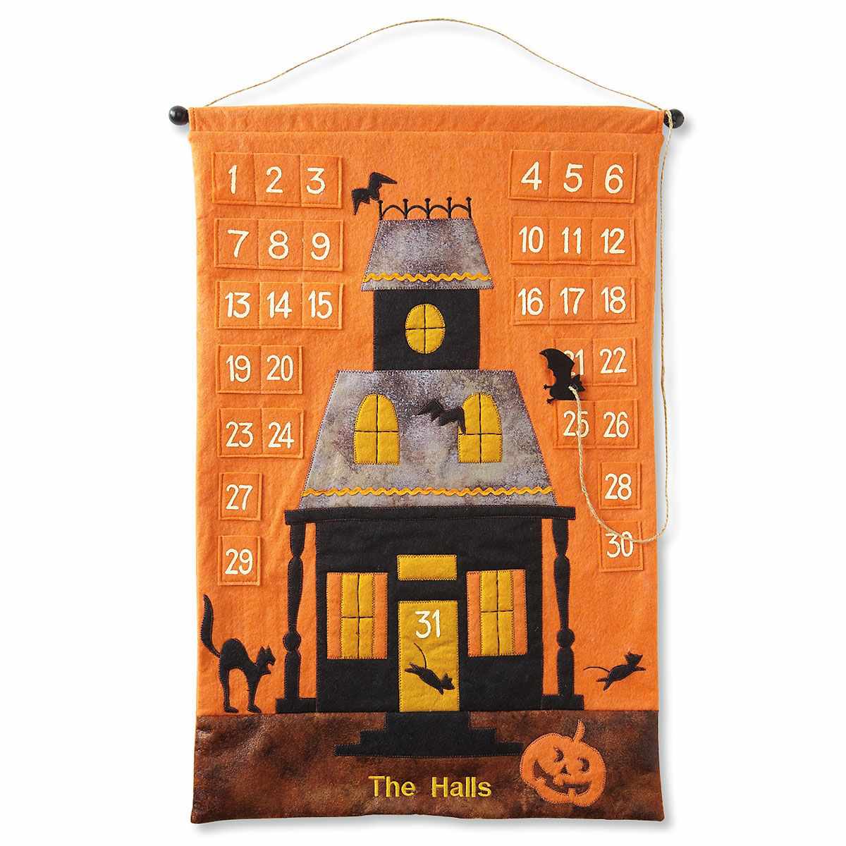 Orange felt wall hanging with 31 pockets and a haunted house design