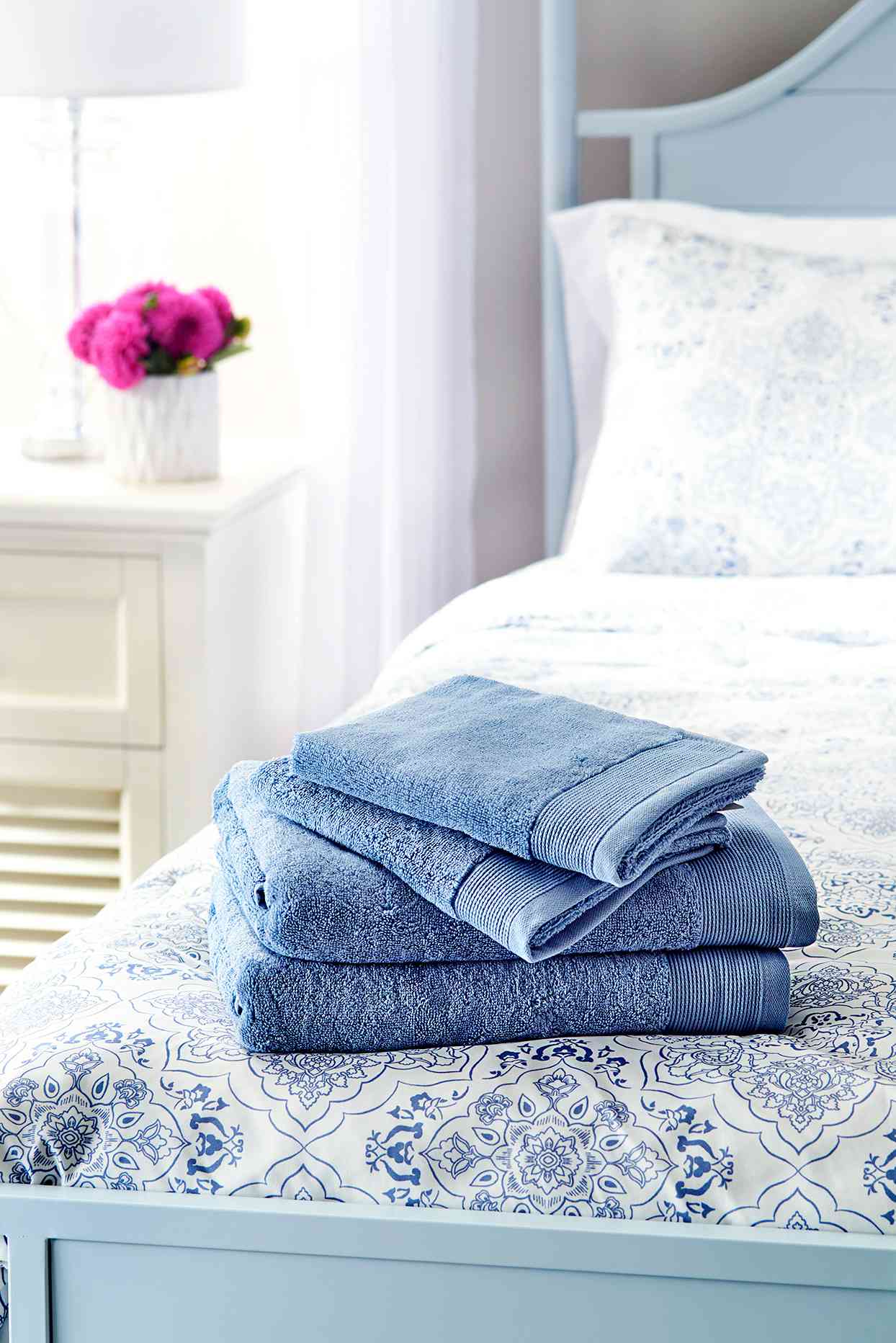 Folded towels sitting on bed