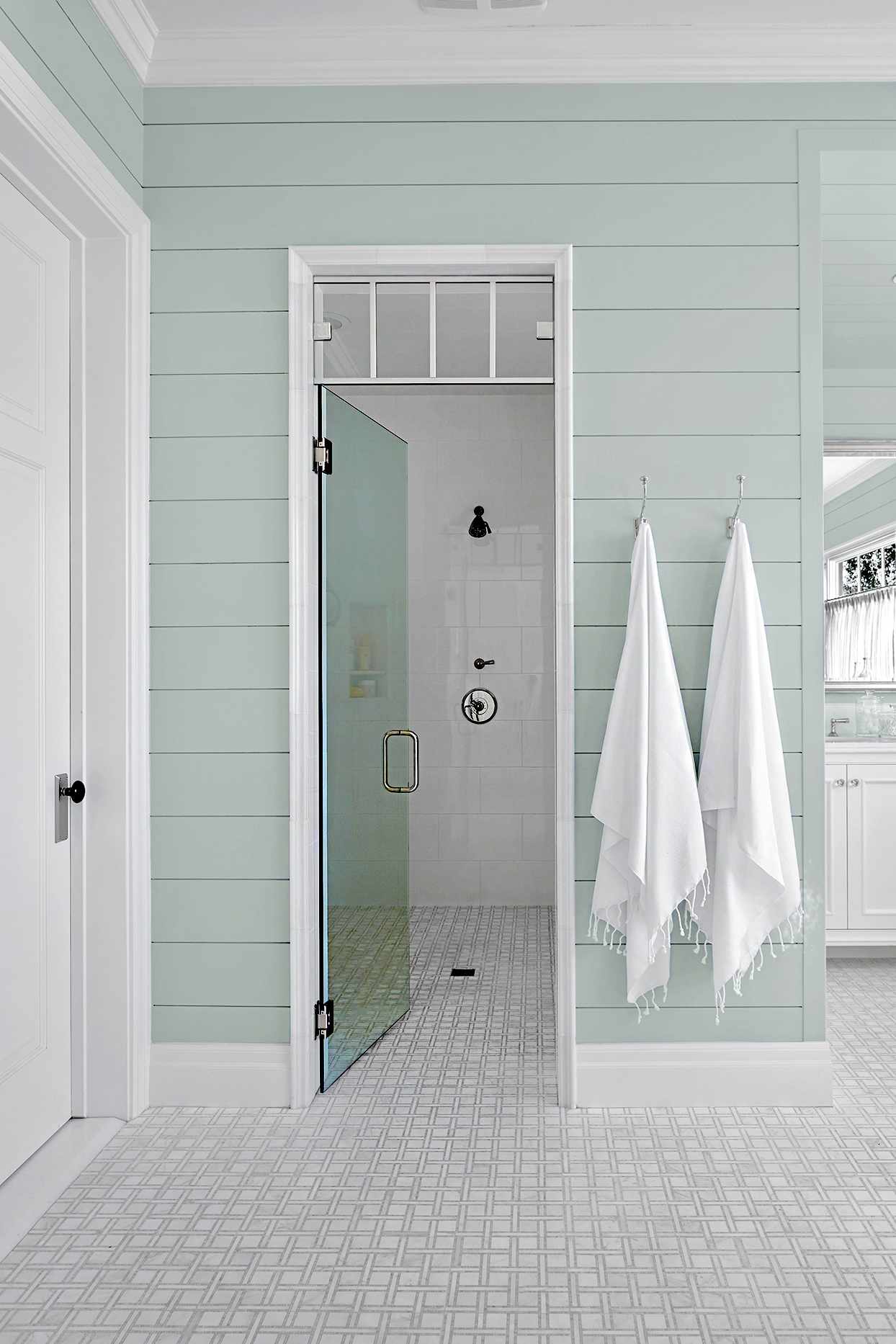 Bathroom with light blue walls and hanging white towels