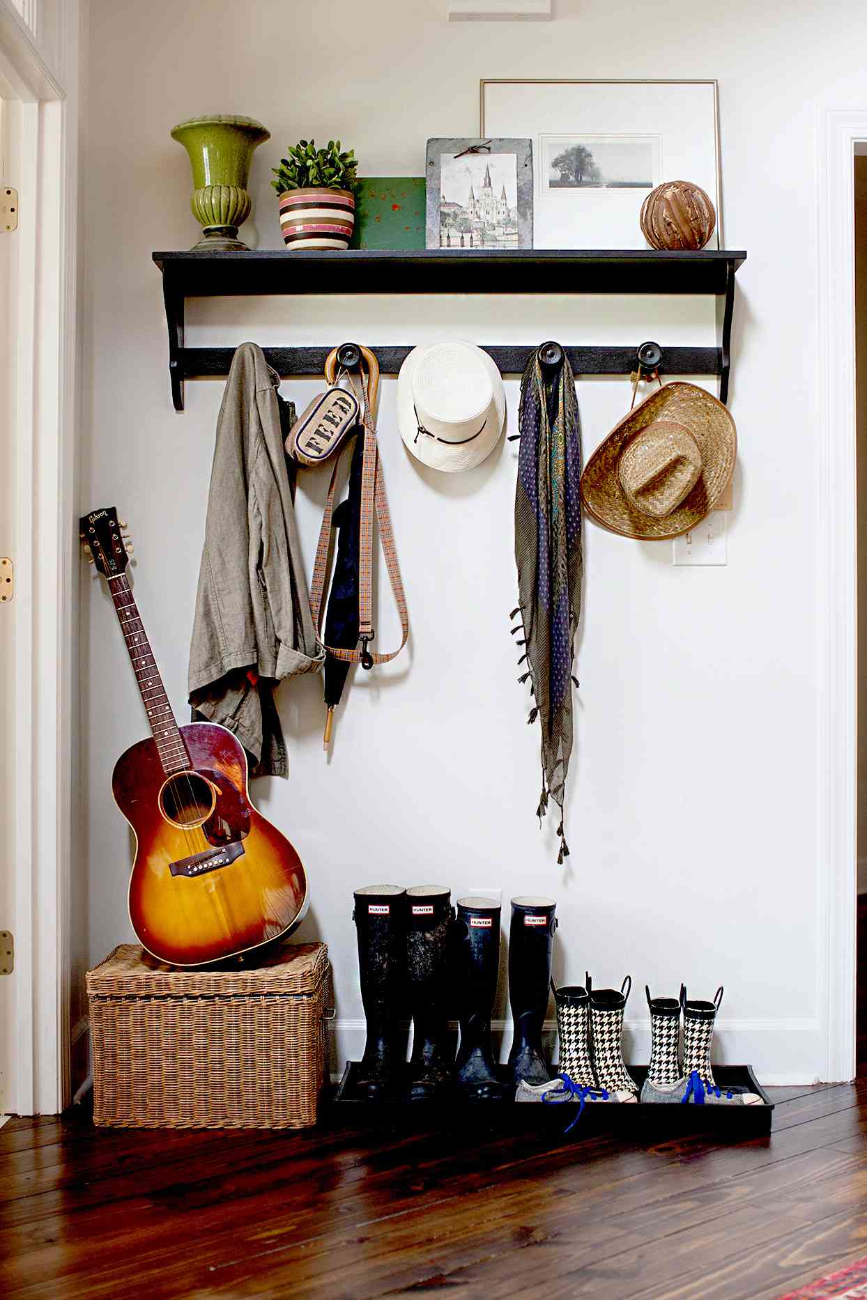 Entryway with hanging organizer, boots, and guitar