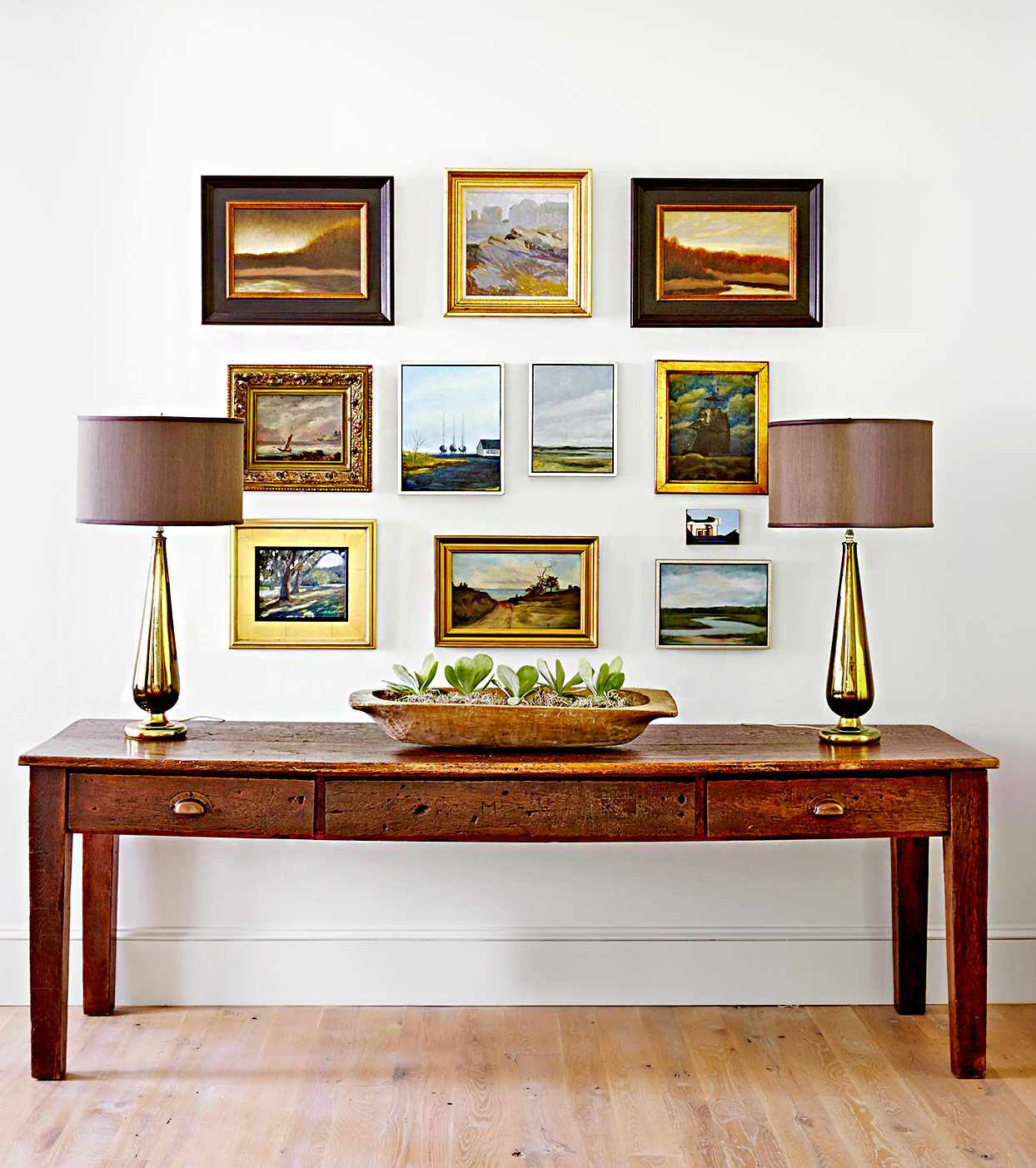 Table with lamps and multiple framed landscapes