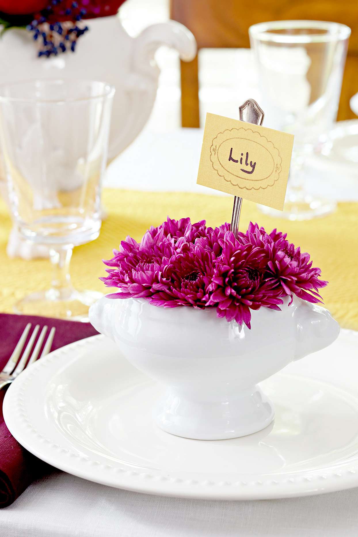 Place setting with purple flowers in ceramic vase