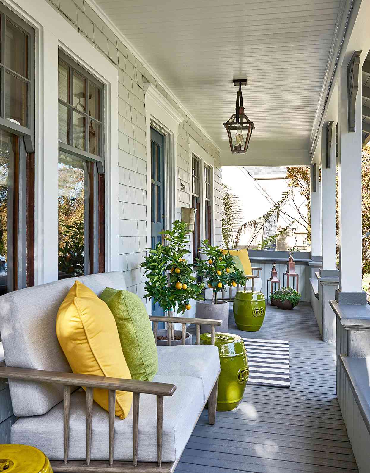 narrow front porch with citrus trees and bold cusions