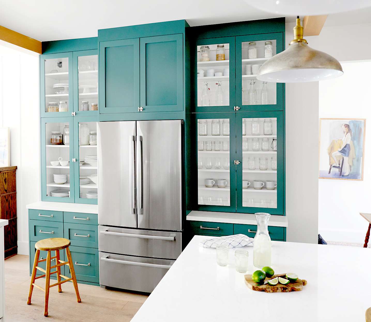 White and teal kitchen with stainless steel fridge