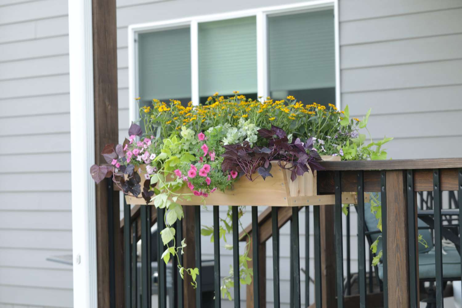 wooden railing planter with assorted plants
