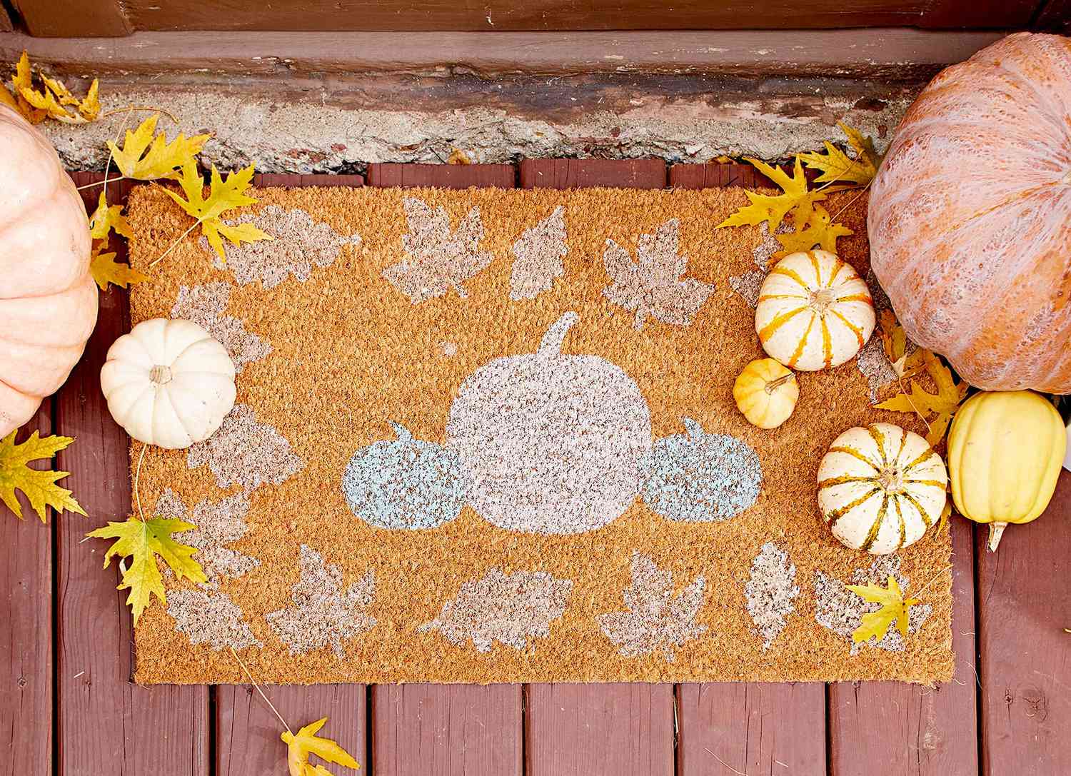 Welcome mat with pumpkins and leaves