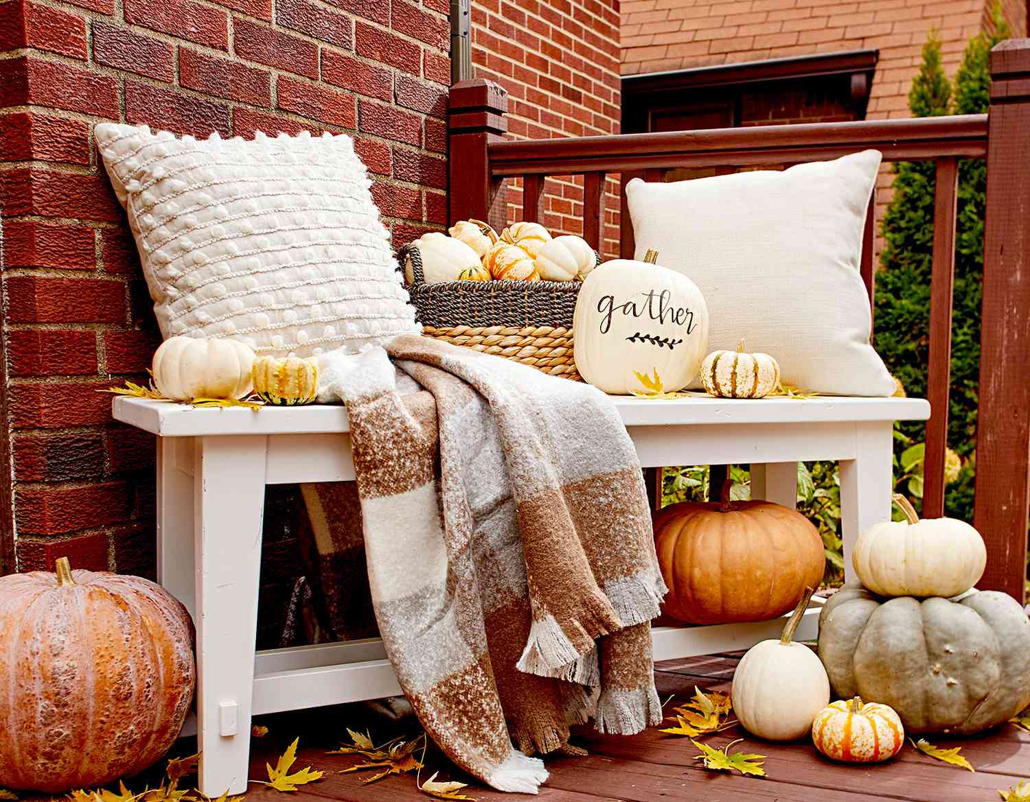 Bench with pumpkins, pillows, and blanket