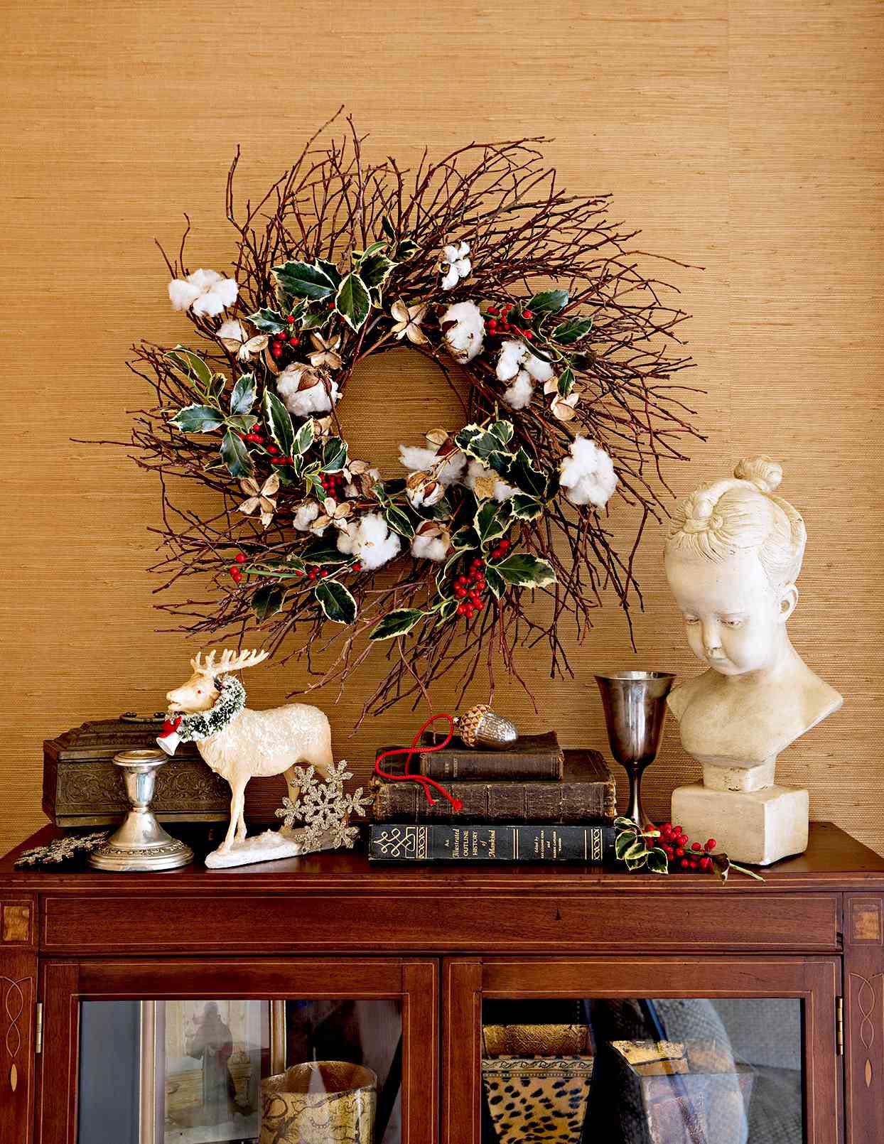 Wooden shelf with wreath made of branches and cotton above