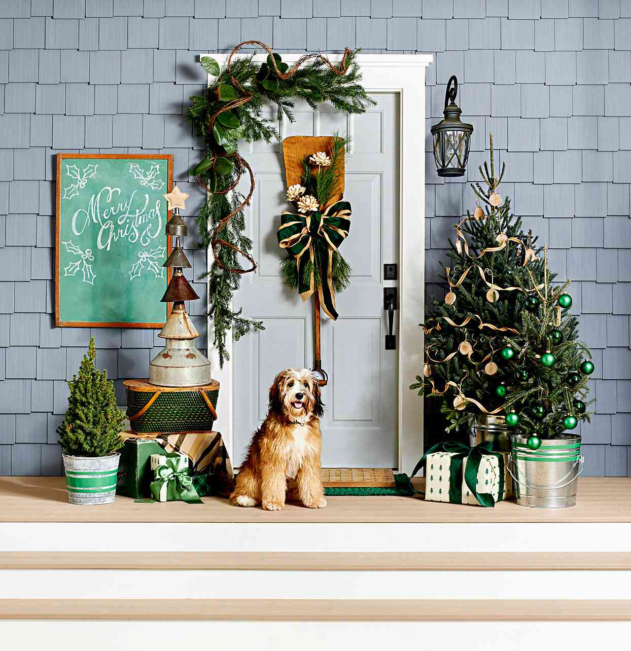 Festive front porch with Christmas tree, bow, and dog