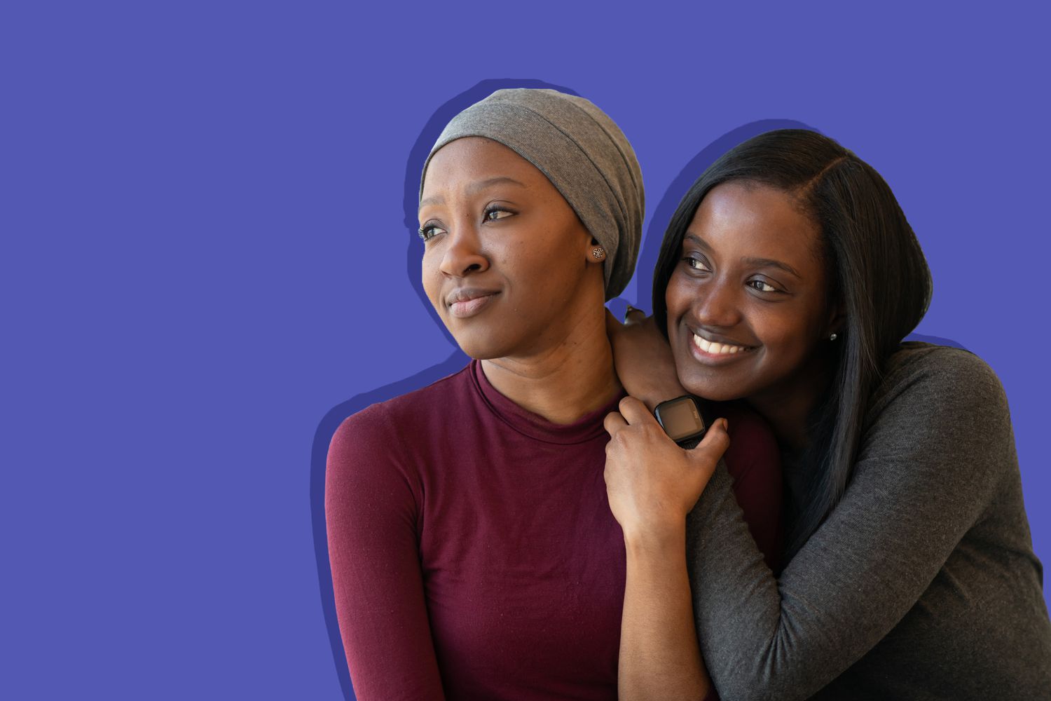 two women standing by each other on purple background