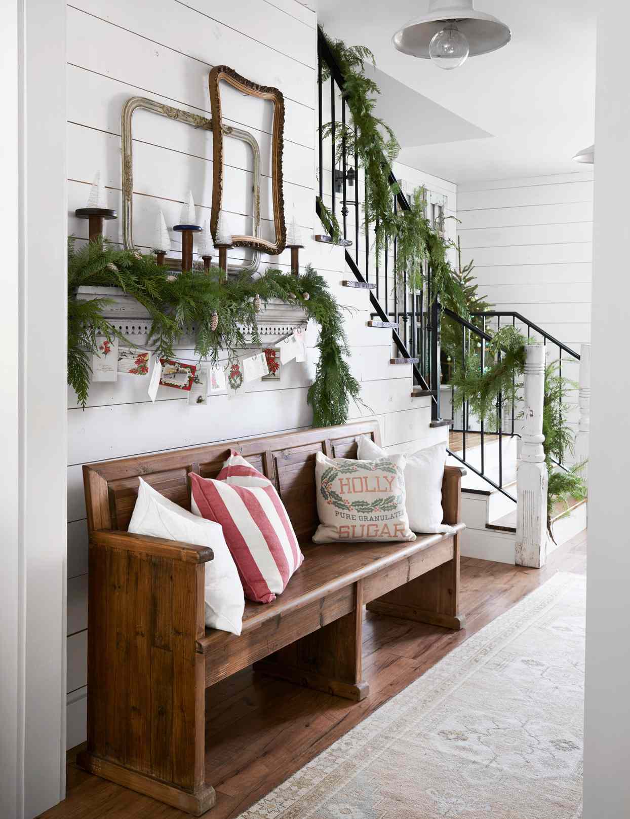 garland covered staircase above wooden bench
