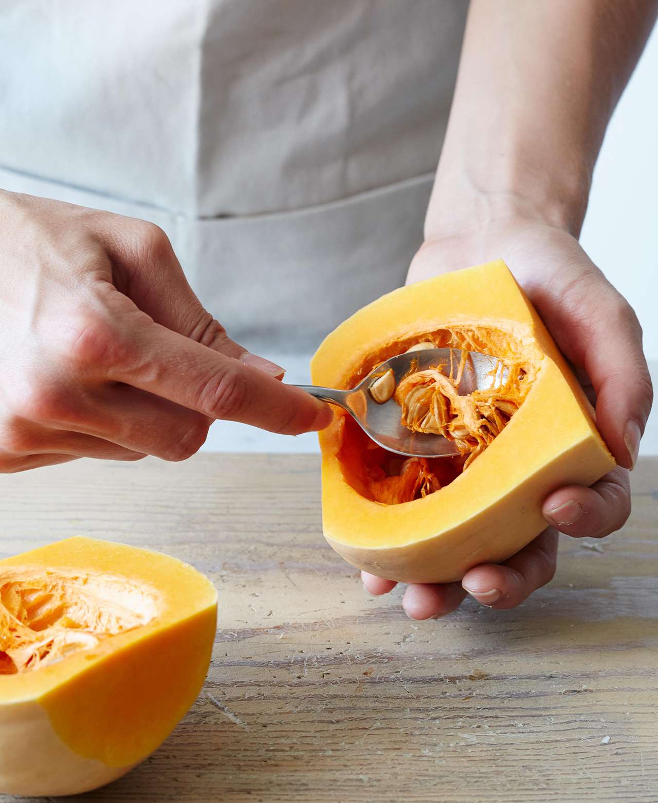 Scooping seeds out of butternut squash