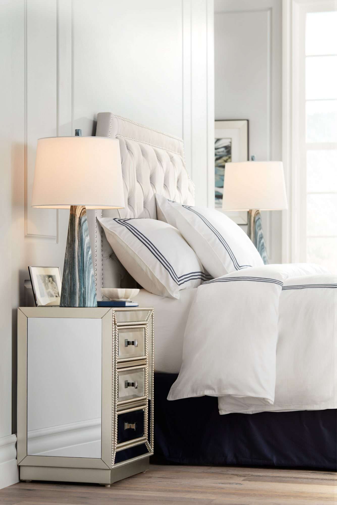 Bed and side tables with lamps in a white and cream palette