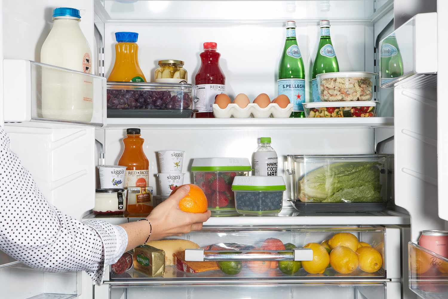 placing orange in organized fridge