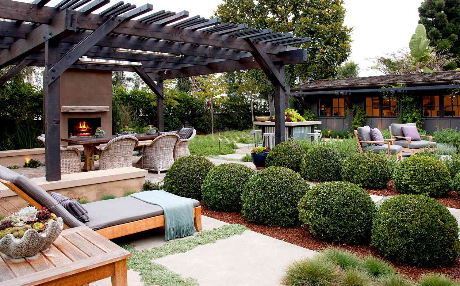 Boxwoods in garden with fireplace and seating