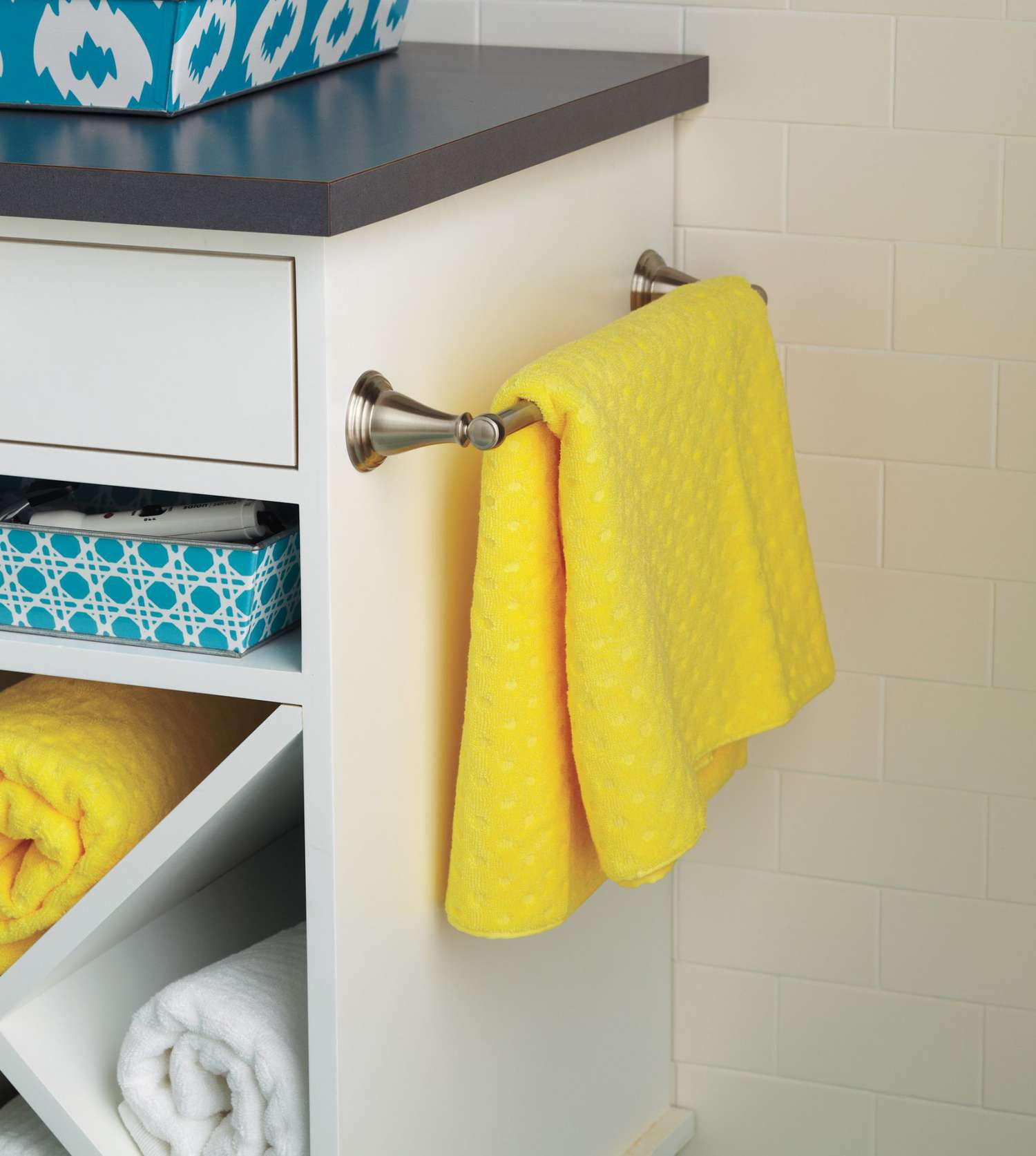 close-up of towel bar on side of vanity with yellow hand towel