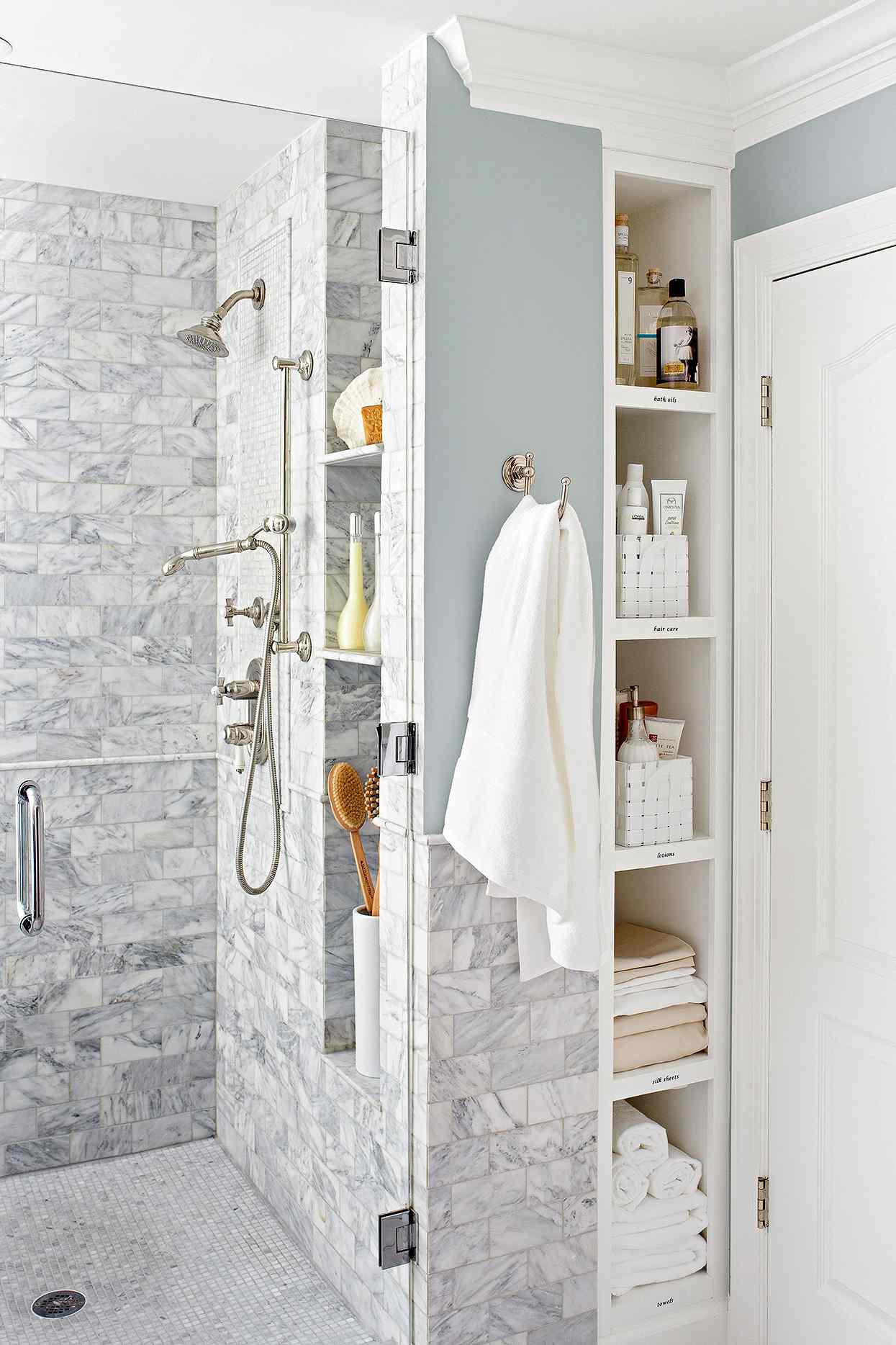 modern bathroom with built-in cubbies and marble tile