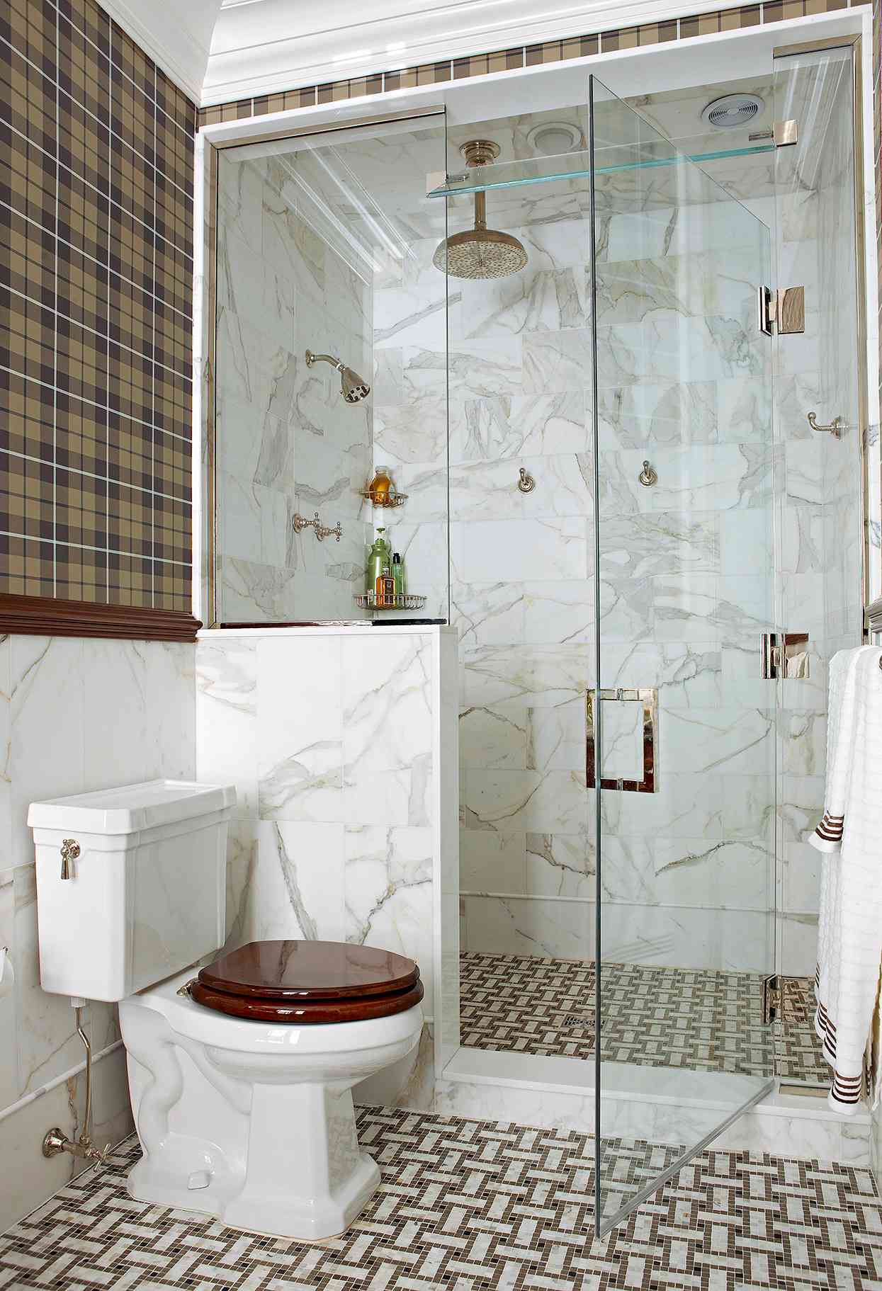 spacious walk-in shower with marble walls and warm tones