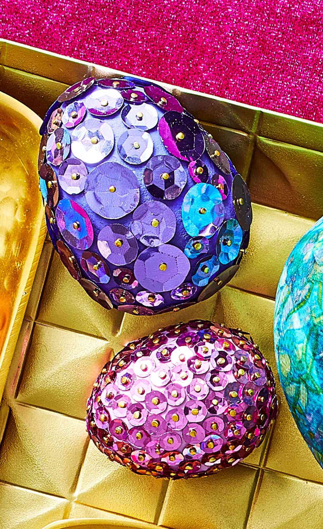 two faux easter eggs covered in pink and purple sequins