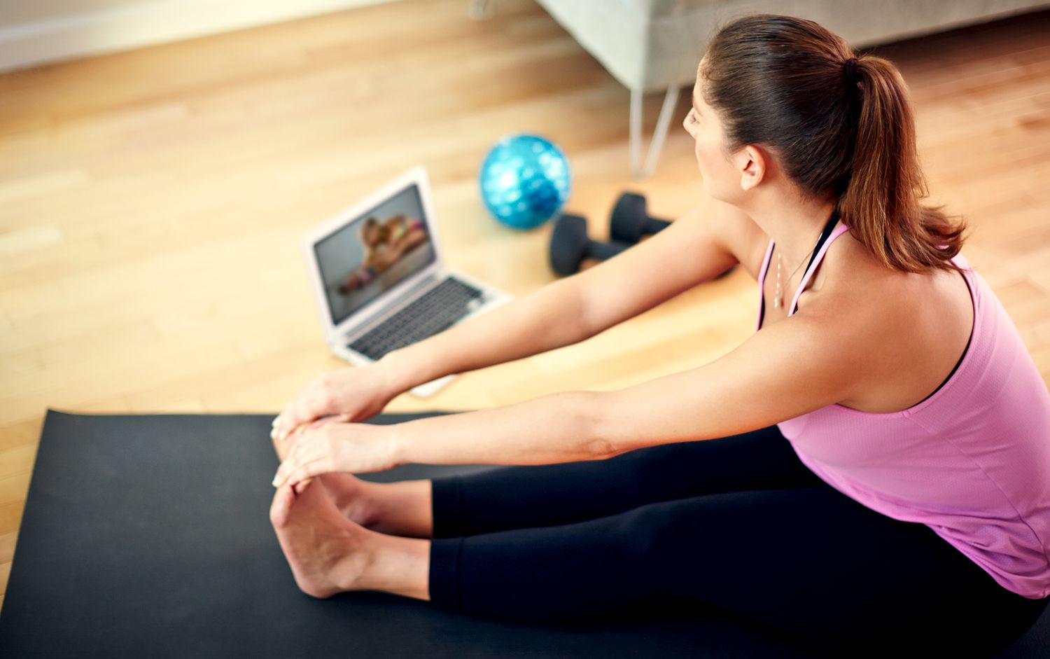 Woman working out at home viewing her laptop