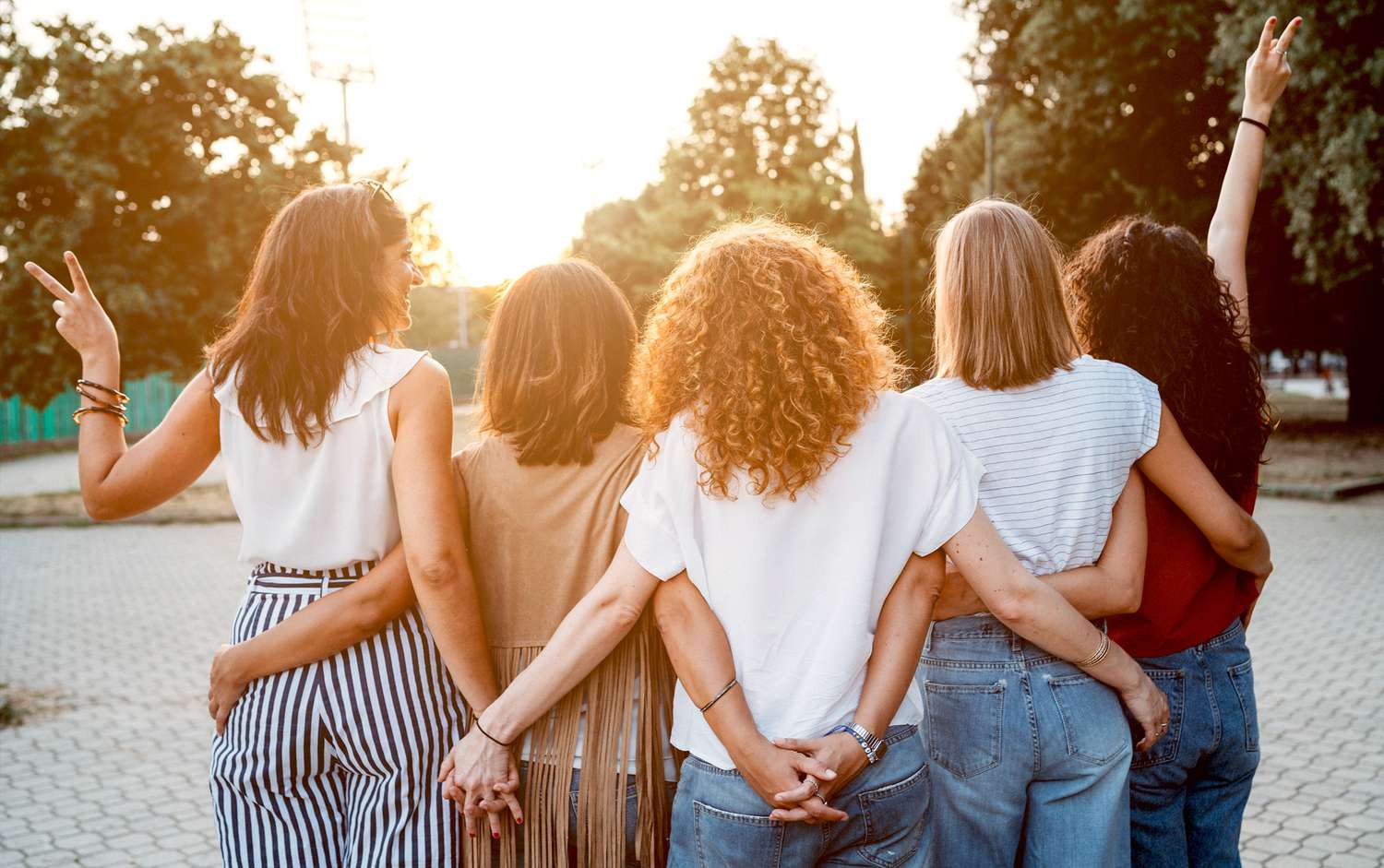Back view of a group of young women holding hands