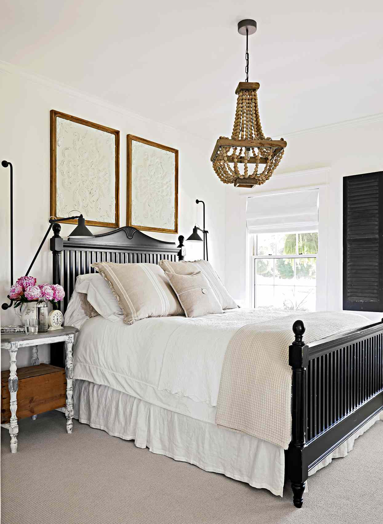 neutral bedroom with black bed frame and beaded light