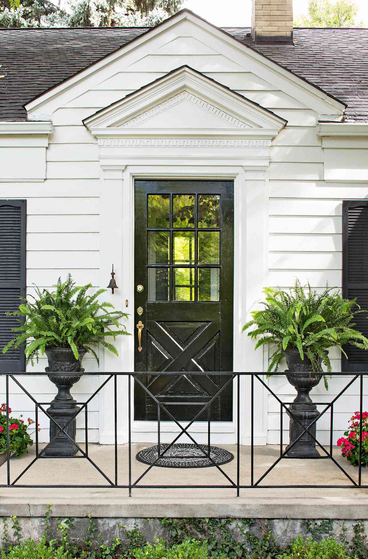 black door with window and wrought iron railing