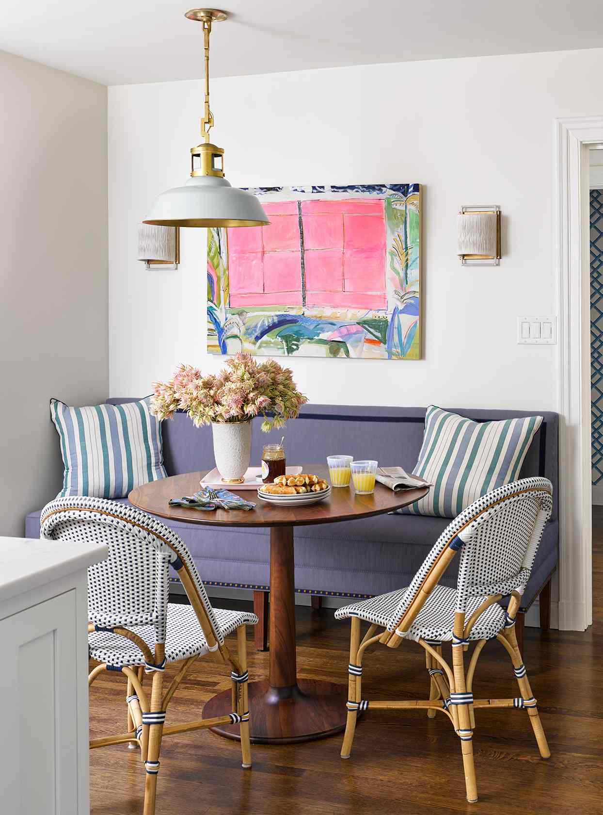 Dining area with blue couch and large artwork