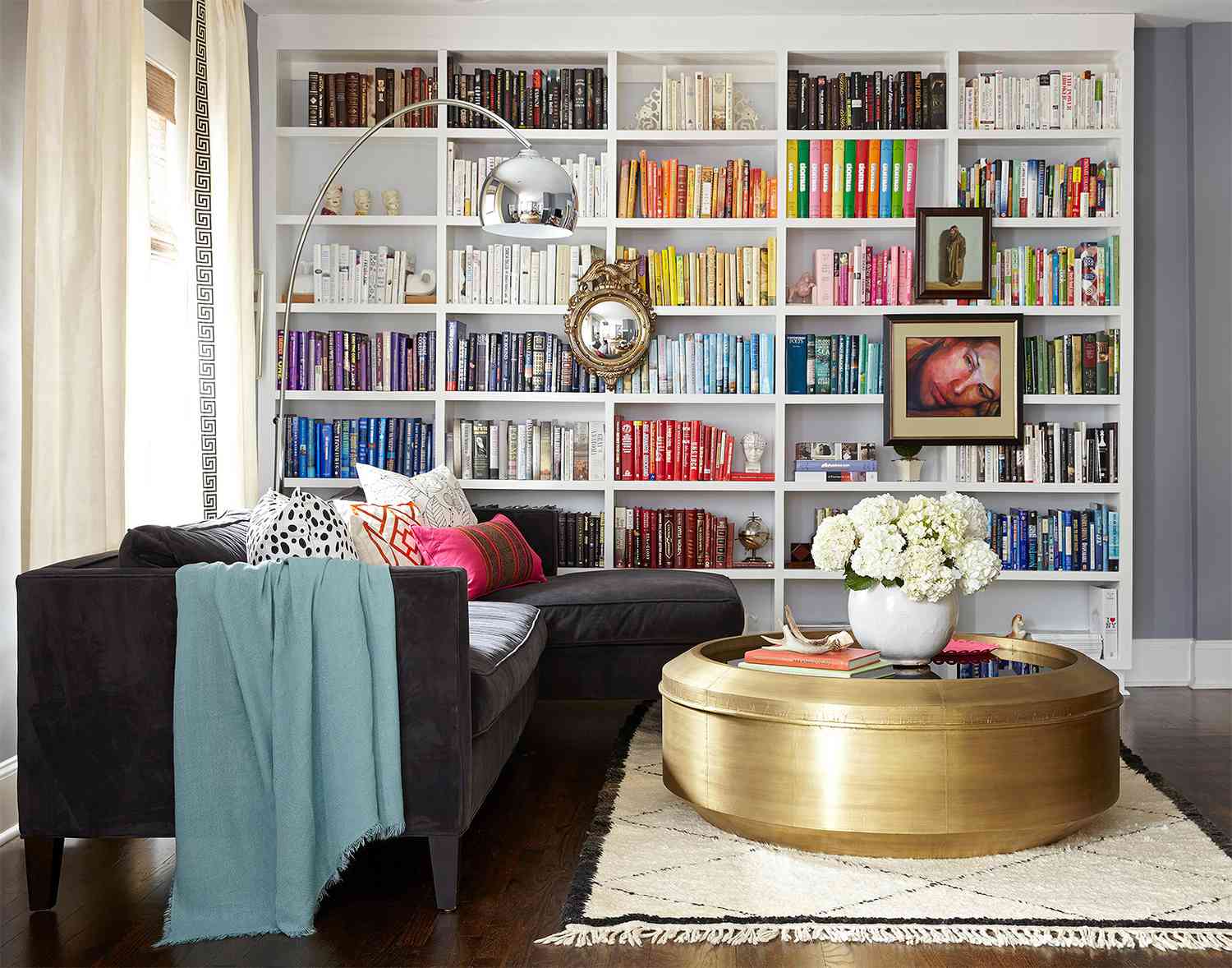 modern living room with black sofa and books arranged by color