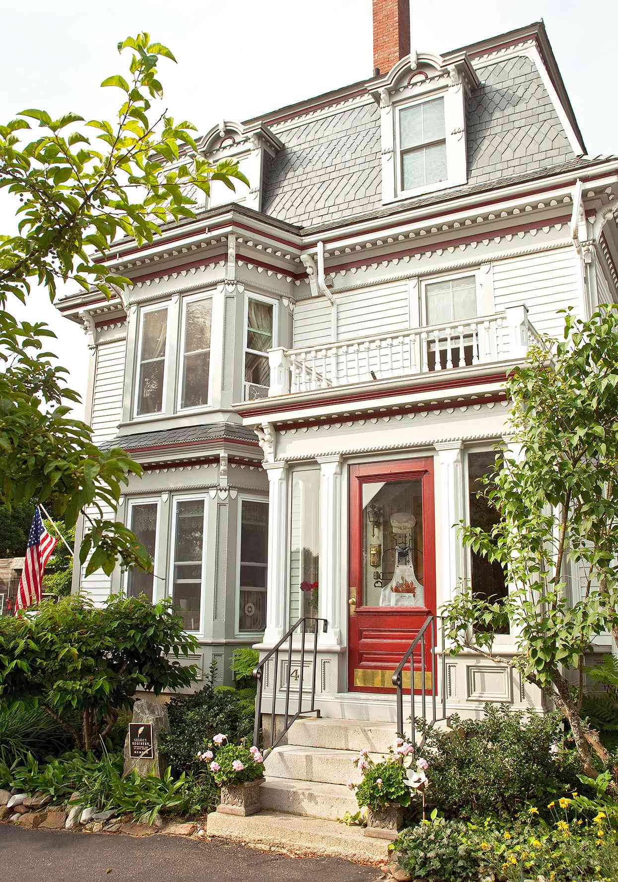 victorian-style home exterior with neutral paint and bright red door
