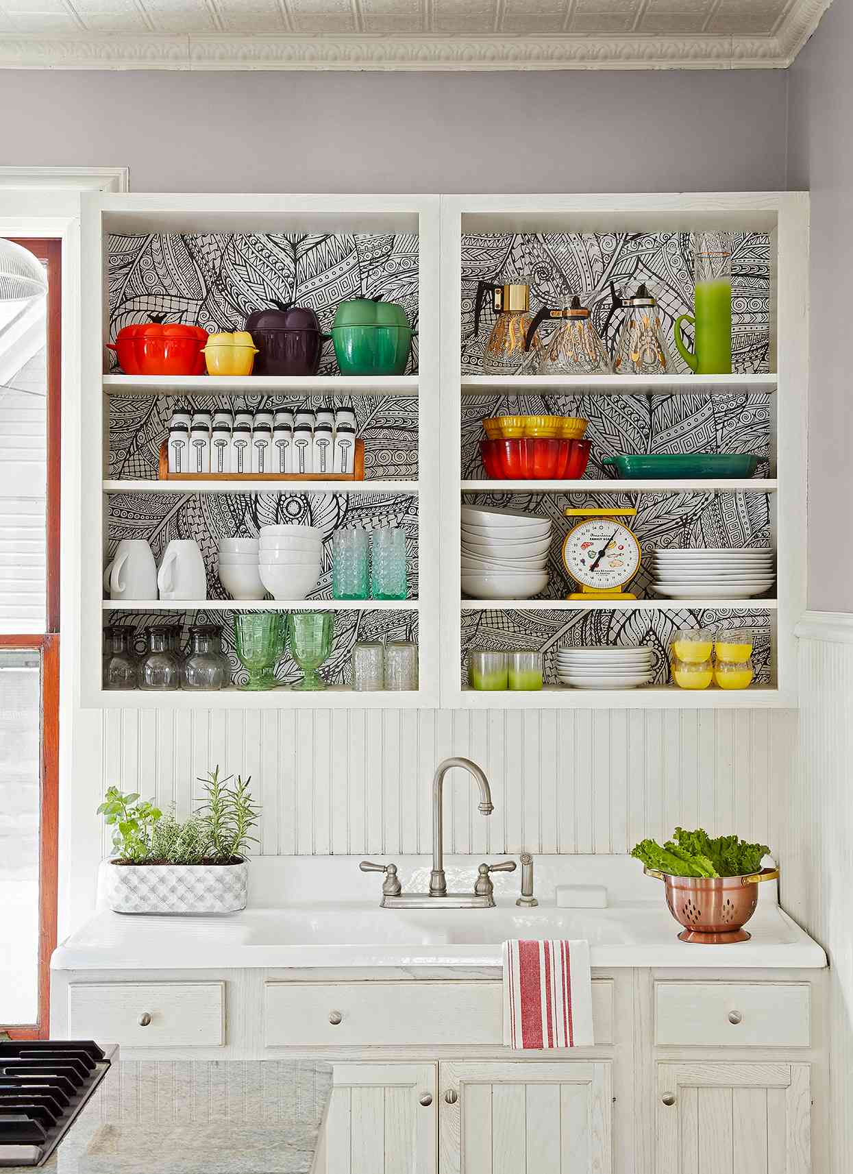 bright dishes in white kitchen open shelving with wallpaper