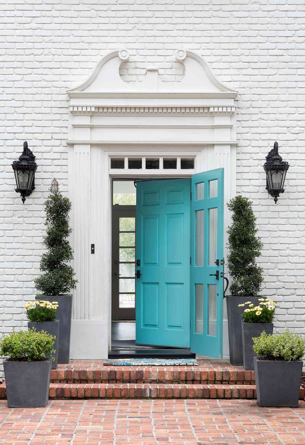 painted white brick exterior with ornate trim and turquoise front door