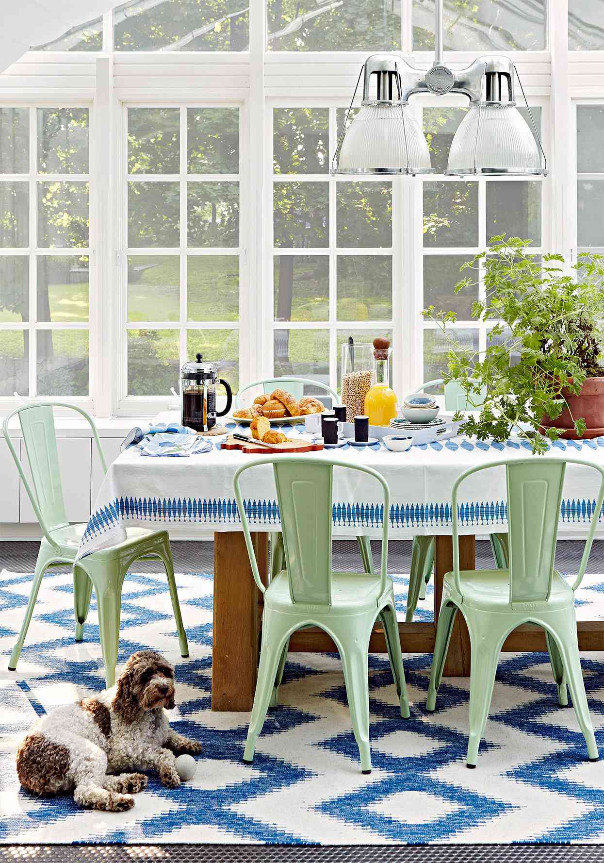 enclosed porch with dining table and mint green retro chairs
